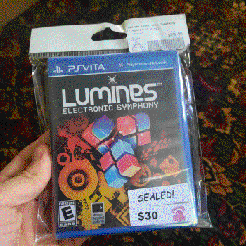 Me holding a sealed copy of Lumines: Electrony Symphony for the PS Vita.